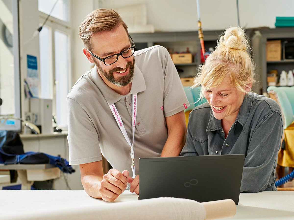 Ein Mann und eine Frau sehen sich etwas zusammen auf einem Laptop an.