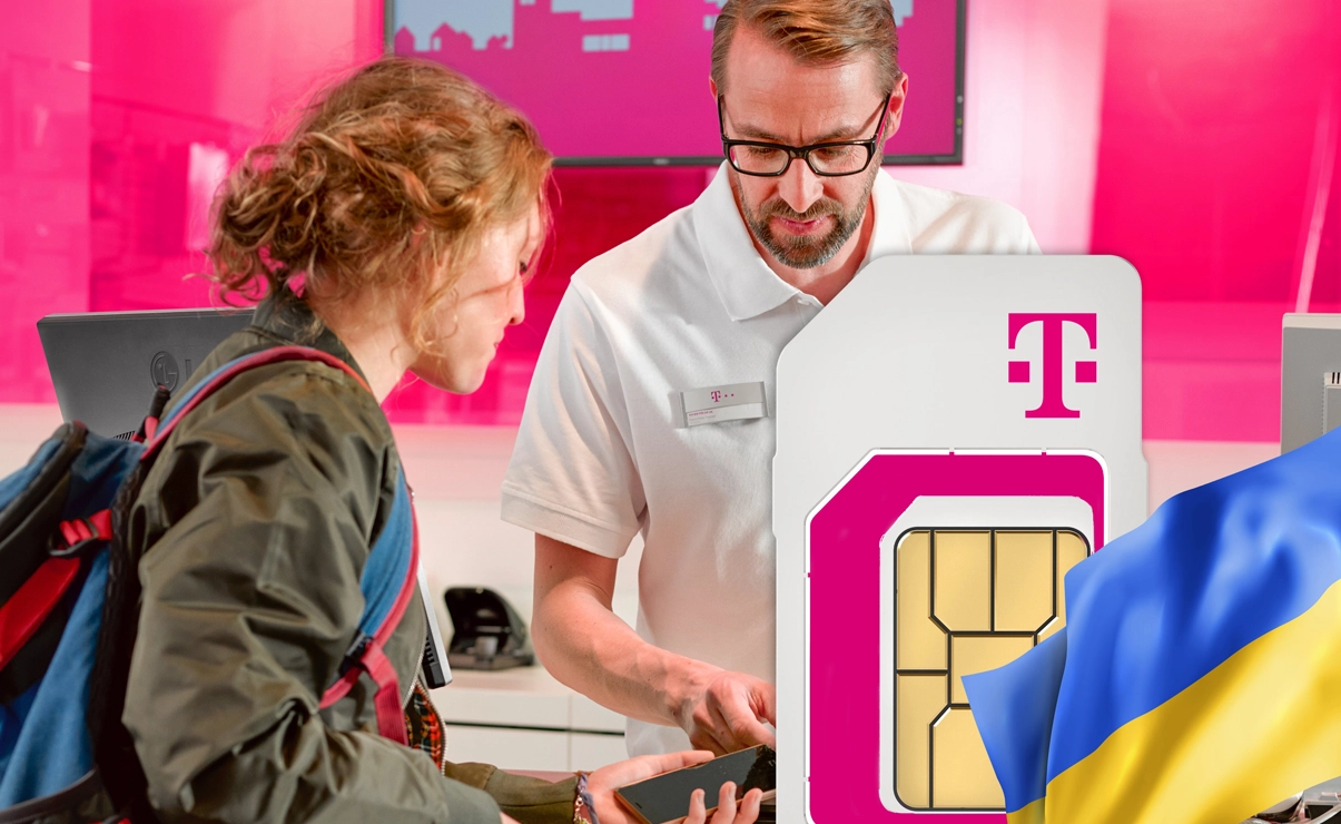 Ein Mann zeigt einer Frau etwas auf einem Smartphone. Sie befinden sich vermutlich in einem Telekom Shop. Im Vordergrund sieht man eine SIM oder Speicherkarte und die Flagge der Ukraine.