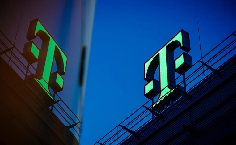 Grünes Telekom Logo mit Spiegelung im nebenliegenden Gebäude (Foto)