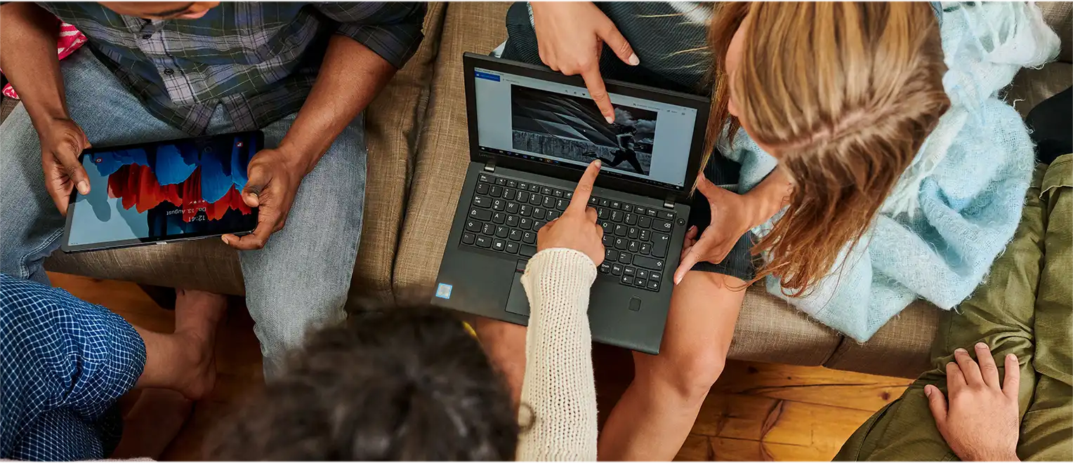 Eine Gruppe von Menschen aus der Vogelperspektive mit einem Laptop und einem Tablet in ihren Händen (Foto)