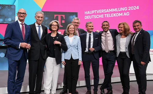 Vorstandsmitglieder der Deutschen Telekom stehend und lächelnd